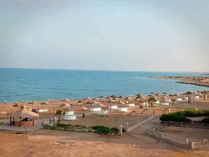 拉斯苏德尔Blue Lagoon Village Ras Sidr (قرية بلولاجون راس سدر) (عائلات فقط)的海滩上放着一把遮阳伞,大海