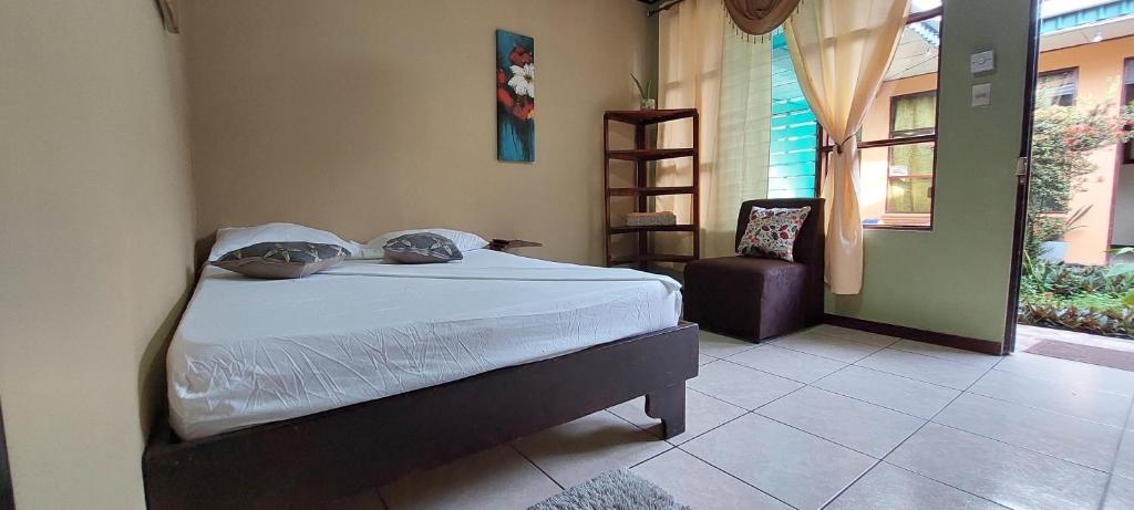 利蒙港Hospedaje Doña koko的卧室配有床、椅子和窗户。