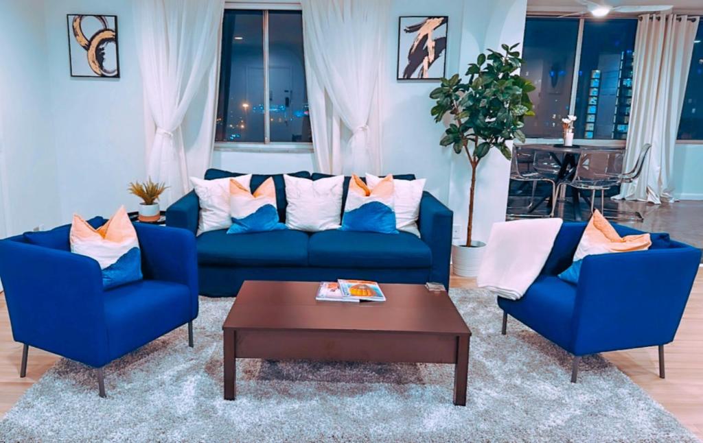 亚特兰大Highrise luxury two bedroom condo in Downtown Atlanta within minutes!!的客厅配有2张蓝色沙发和1张咖啡桌