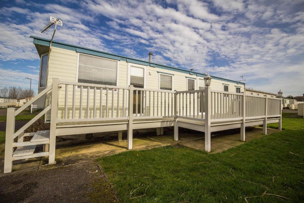 亨斯坦顿Caravan With Decking At Manor Park, Nearby Hunstanton Beach Ref 23013c的移动房屋设有门廊和围栏