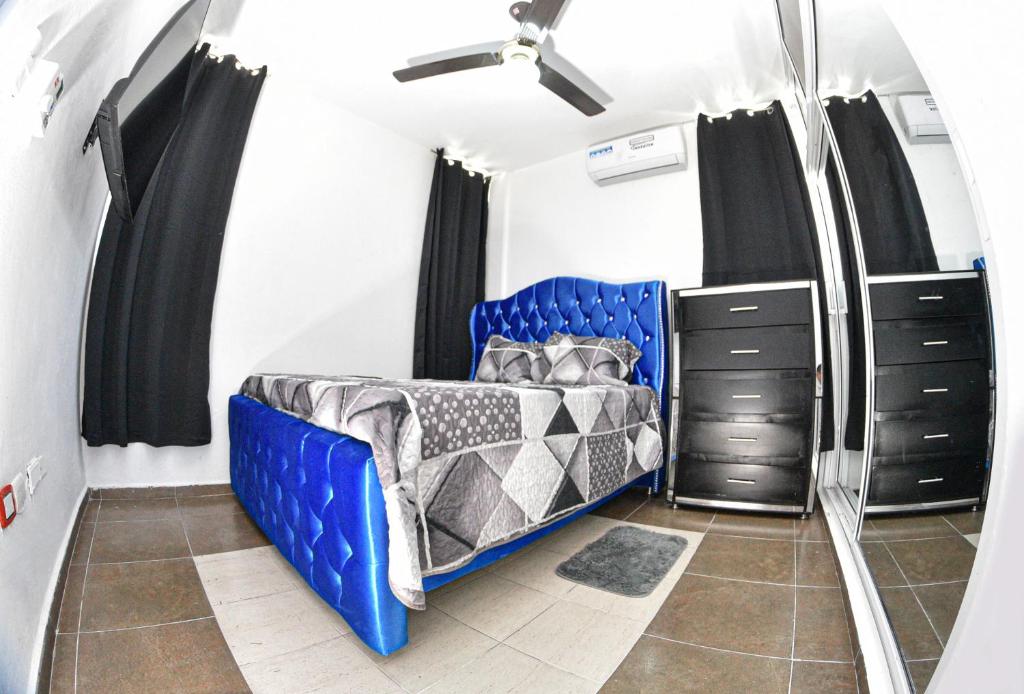 圣地亚哥洛斯卡巴las carreras centro D la ciudad的一间卧室配有一张蓝色的床和黑色橱柜。