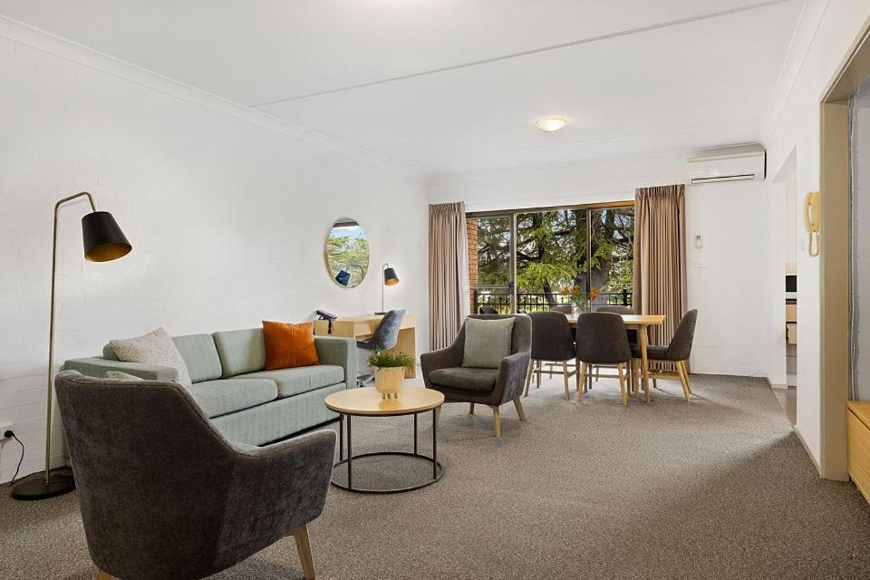 堪培拉奥克斯利阁服务公寓的客厅配有沙发、椅子和桌子