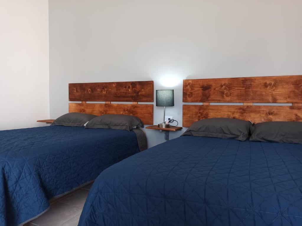 佩尼亚斯科港Your Bedroom的配有蓝色棉被的客房内的两张床