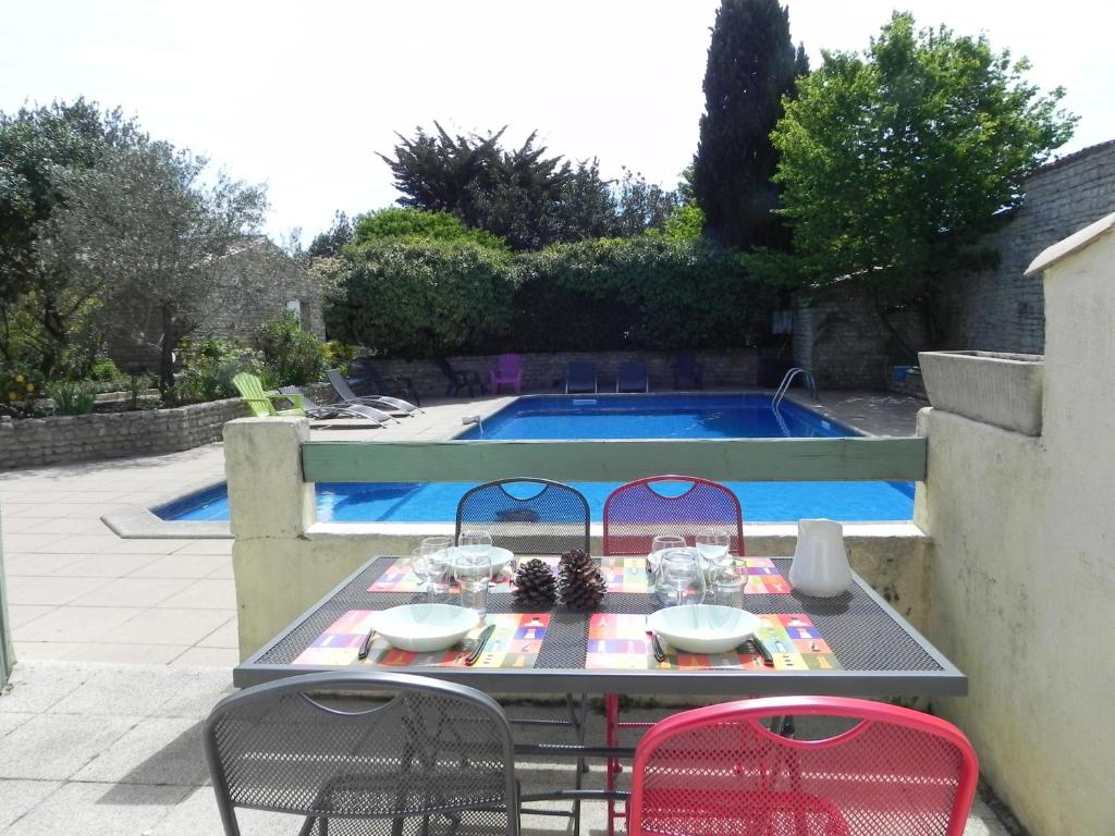 拉弗洛特VILLA DEL RE 3 face à la piscine的游泳池旁一张桌子和四把椅子