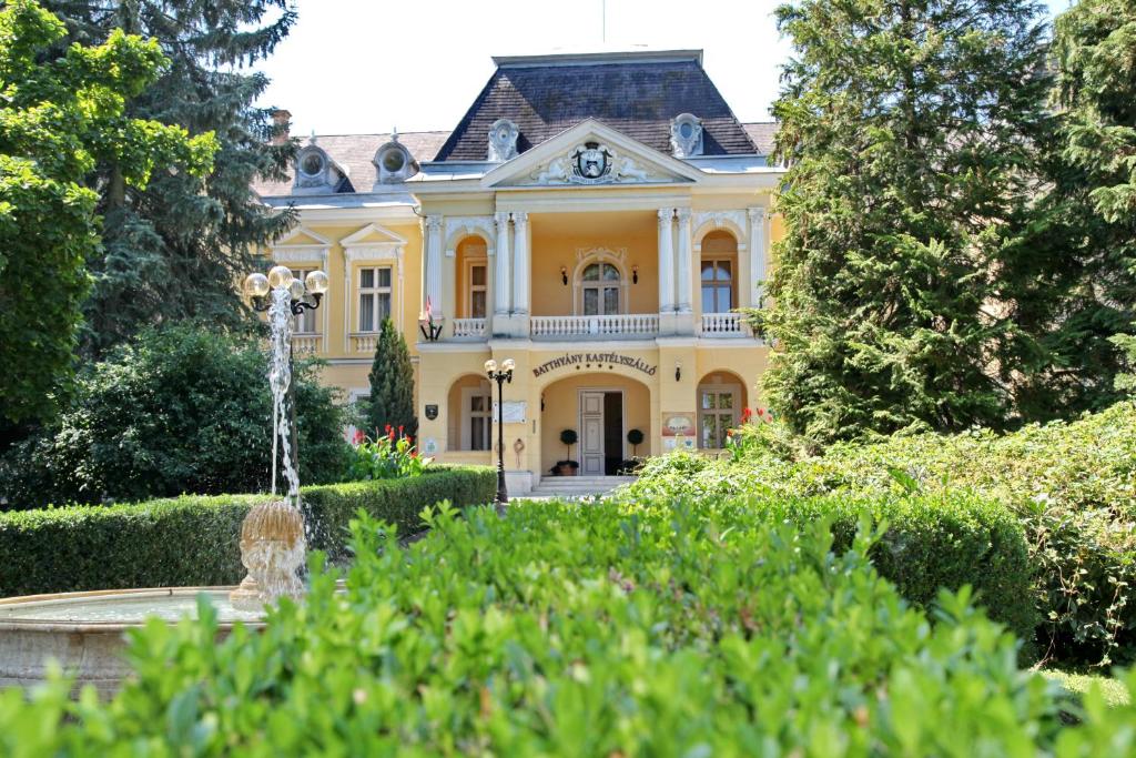 佐洛恰尼包贾尼城堡酒店的一座黄色的房子,前面有一个喷泉