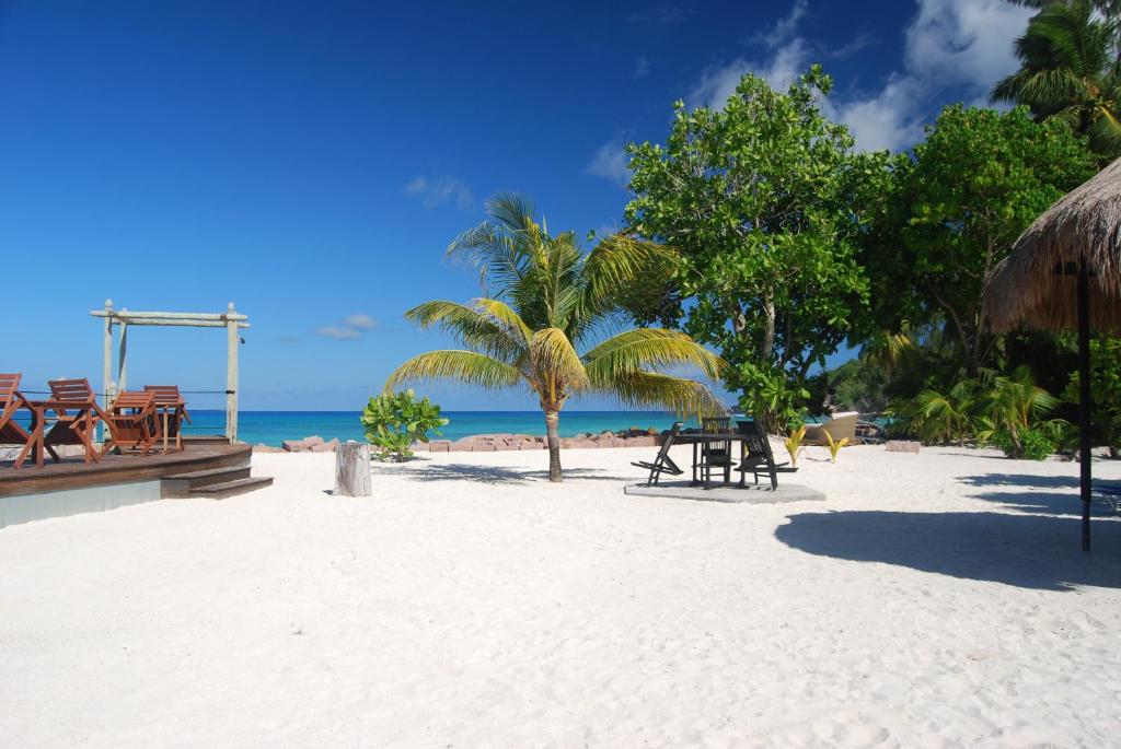 普拉兰大安塞区艾斯兰德酒店的海滩上设有桌椅,大海上设有沙滩
