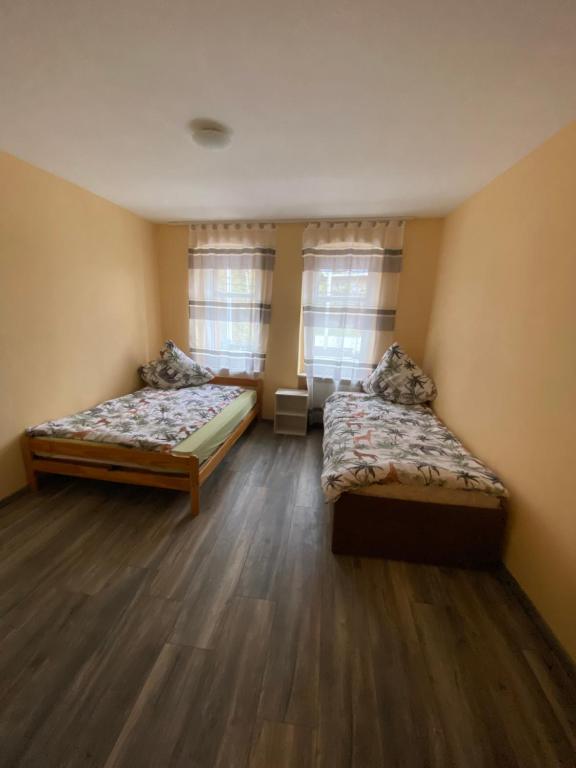 GiebichensteinGrand Wohnungen的客房内设有两张床,铺有木地板,设有窗户。