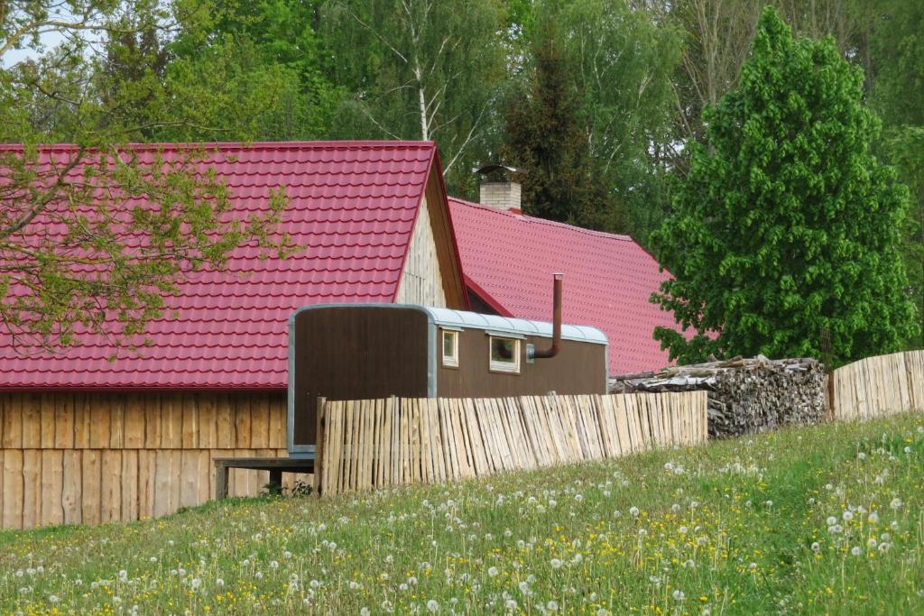 PoběžoviceMaringotka na samotě na kozí farmě的粉红色屋顶和木栅栏的房子