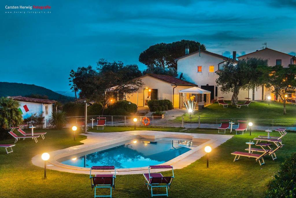 马萨马里蒂马Agriturismo Baia degli Ulivi的一座晚上设有游泳池的房子