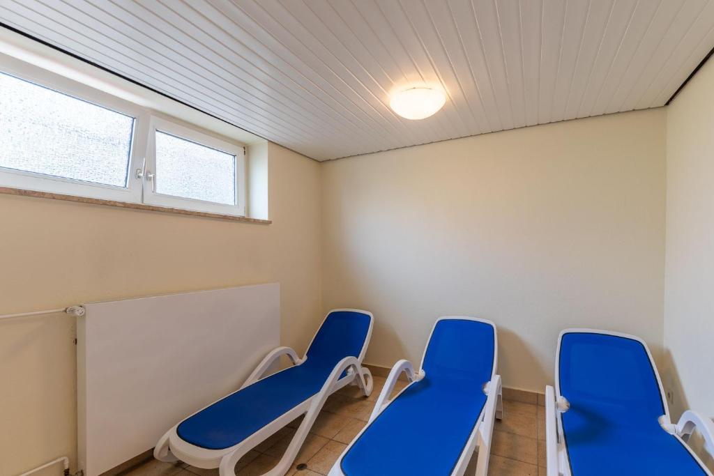 杜亨Haus Medemsand, Whg 214的一间房间,房间内设有两把蓝色椅子