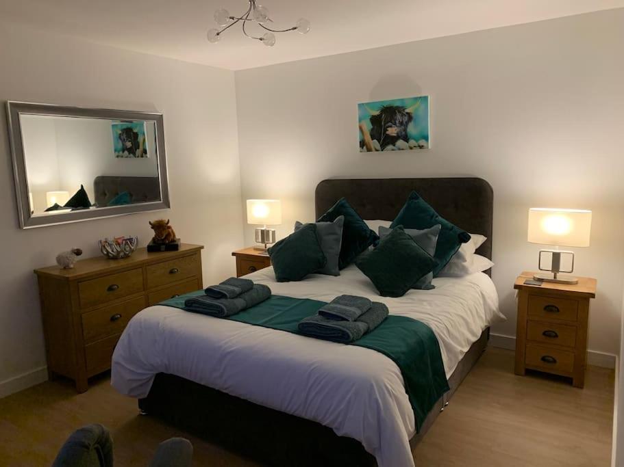 SkeabostCruachan Cabin的一间卧室配有一张带绿色枕头的大床