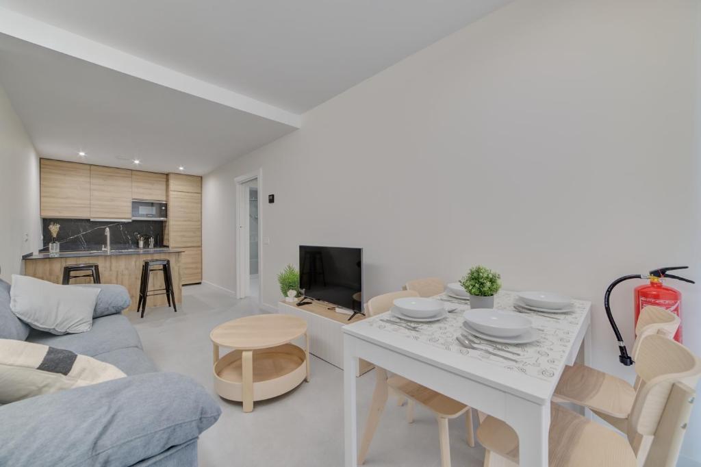 潘普洛纳Apartamentos Pamplona Confort by Clabao的白色的客厅配有桌子和沙发