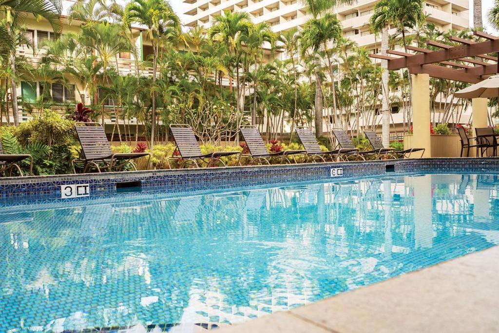 檀香山S&N Lux Suite-Free Parking-King Bed-Kitchen-WiFi的一座带椅子的酒店游泳池,一座建筑