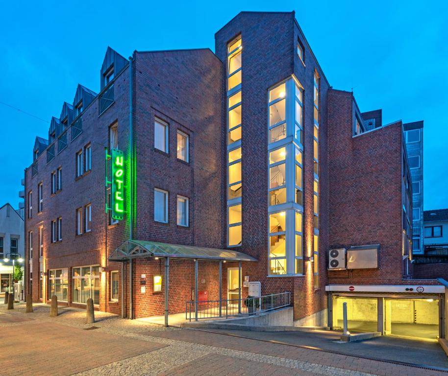 弗希塔HOTEL BREMER TOR, Bestes Hotelfrühstück, Self-Check-In 24 h的砖砌的建筑,上面有绿色的标志