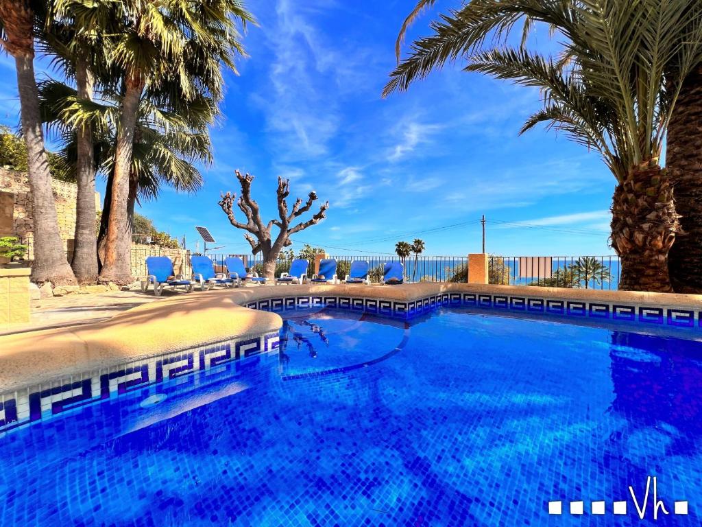 贝尼萨VH CostaBlanca - EVA的一座棕榈树和蓝天的大型游泳池