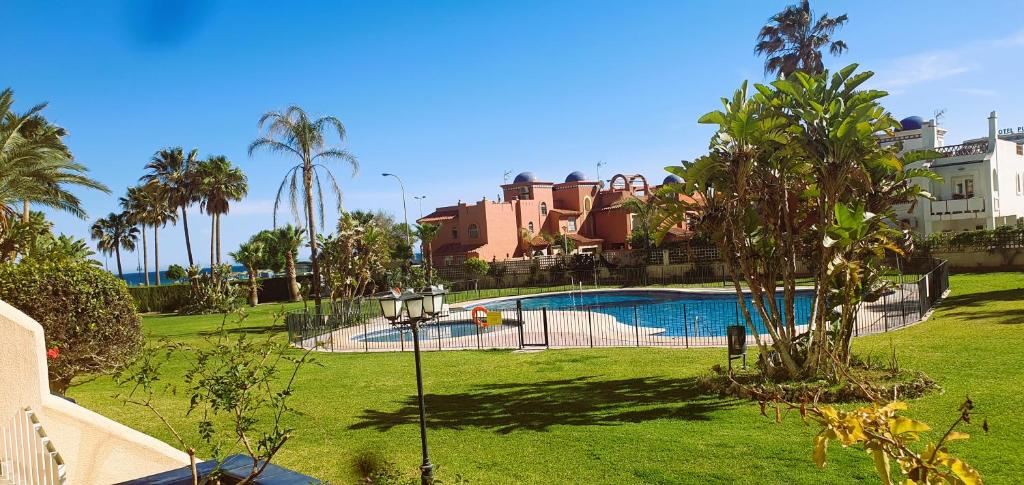 多列毛利诺斯Vive la vida: Torremolinos (1ª línea)的棕榈树和建筑的庭院内的游泳池