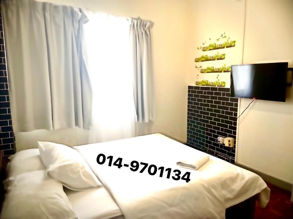彭亨Selesa hill homestay的一间卧室设有一张床、一台电视和一个窗口。