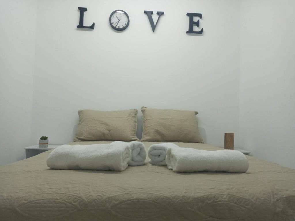 亚实基伦רימון יחידות אירוח Vacation units RIMON的一张带两个枕头的床和墙上的时钟