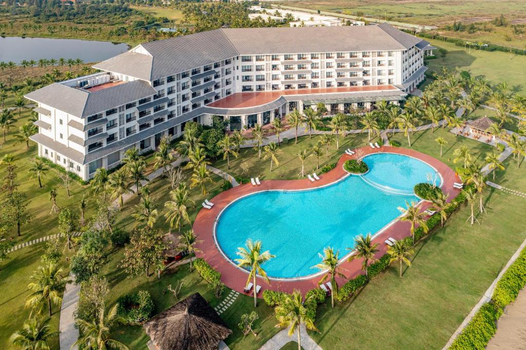 格卢市社Melia Vinpearl Cua Hoi Beach Resort的享有带游泳池的度假村的空中景致