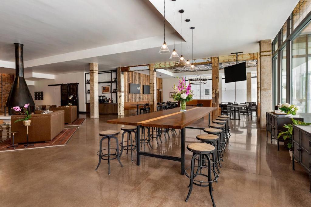 米苏拉Residence Inn by Marriott Missoula Downtown的大型用餐室设有一张大木桌和凳子