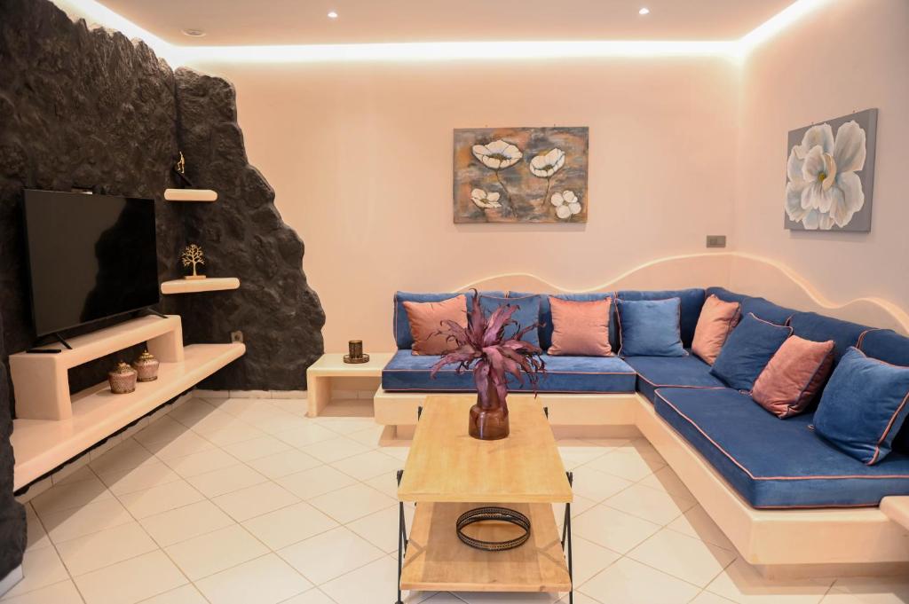 梅萨雷亚THE ROCK LUXURY HOMES的客厅配有蓝色的沙发和电视