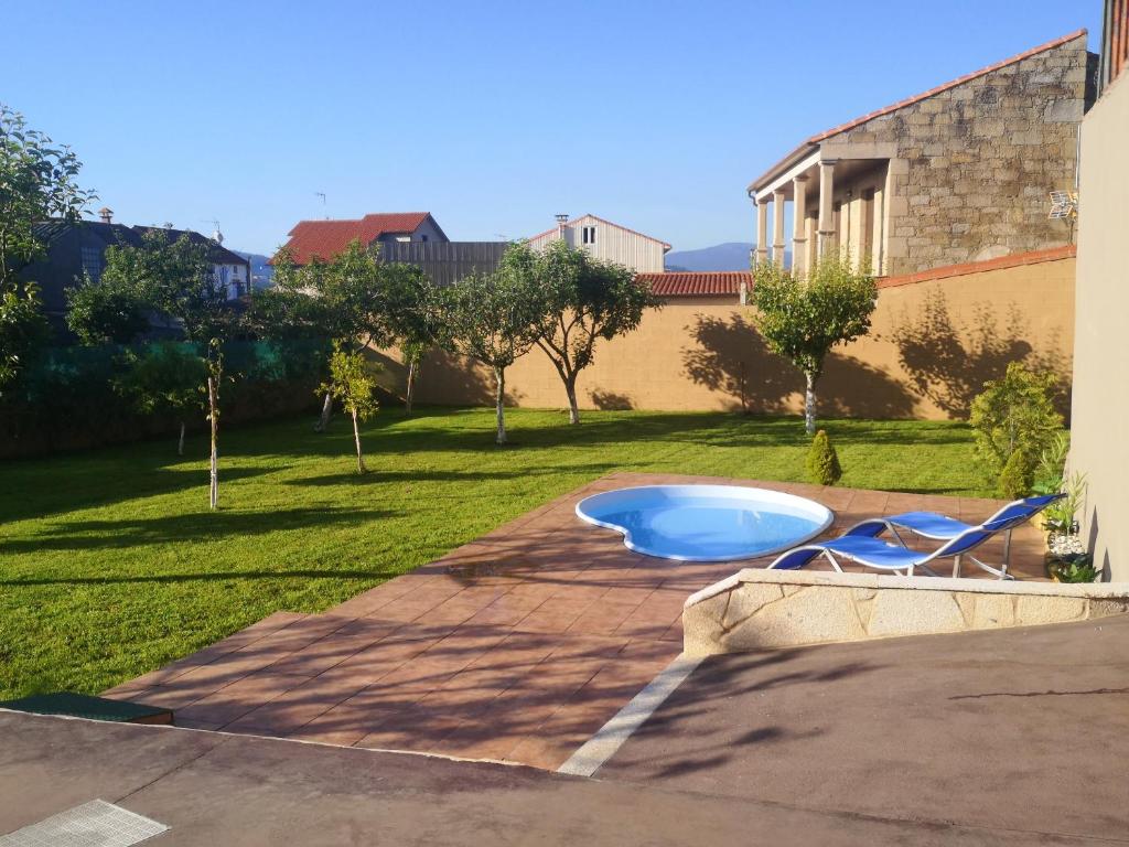 Esteiro4 bedrooms house at Esteiro 53 m away from the beach with enclosed garden and wifi的庭院内带蓝色浴缸的游泳池