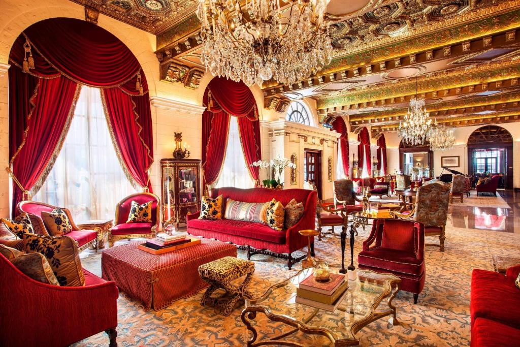华盛顿华盛顿特区瑞吉酒店的大型客厅配有红色家具和吊灯