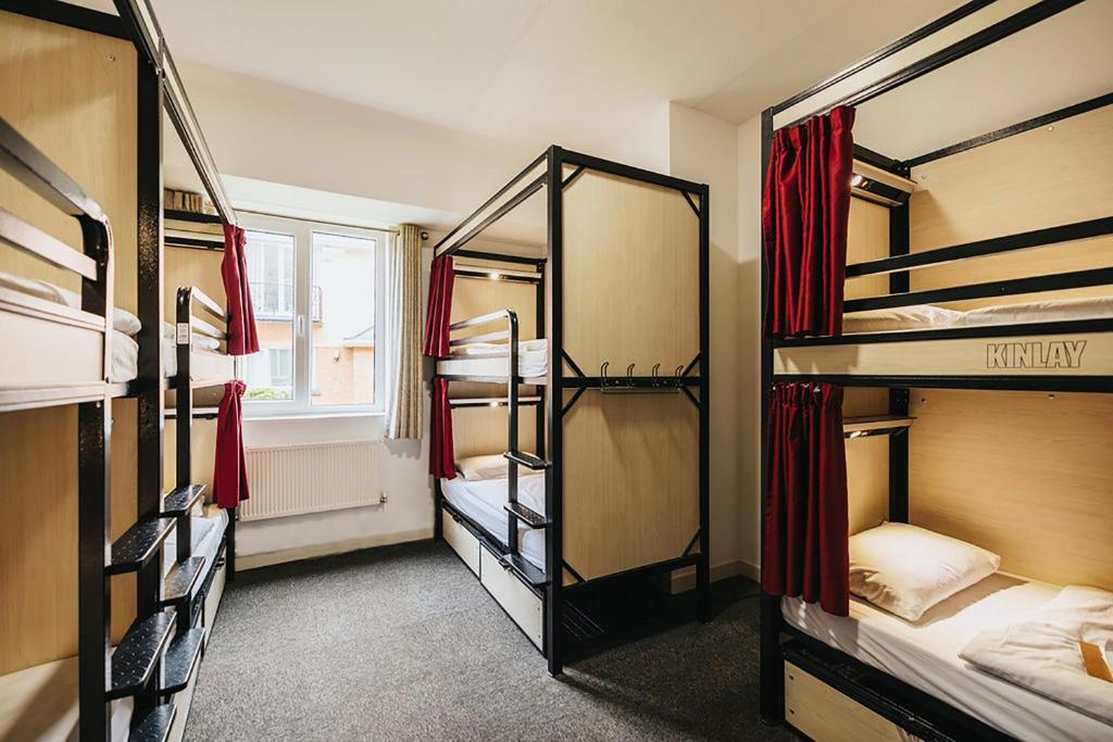 戈尔韦Kinlay Hostel Eyre Square的客房设有三张双层床和一扇窗户。