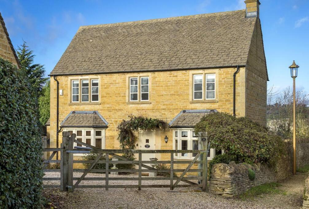 奇平卡姆登Chipping Campden - Cotswolds private house with garden的前面有木栅栏的黄色房子