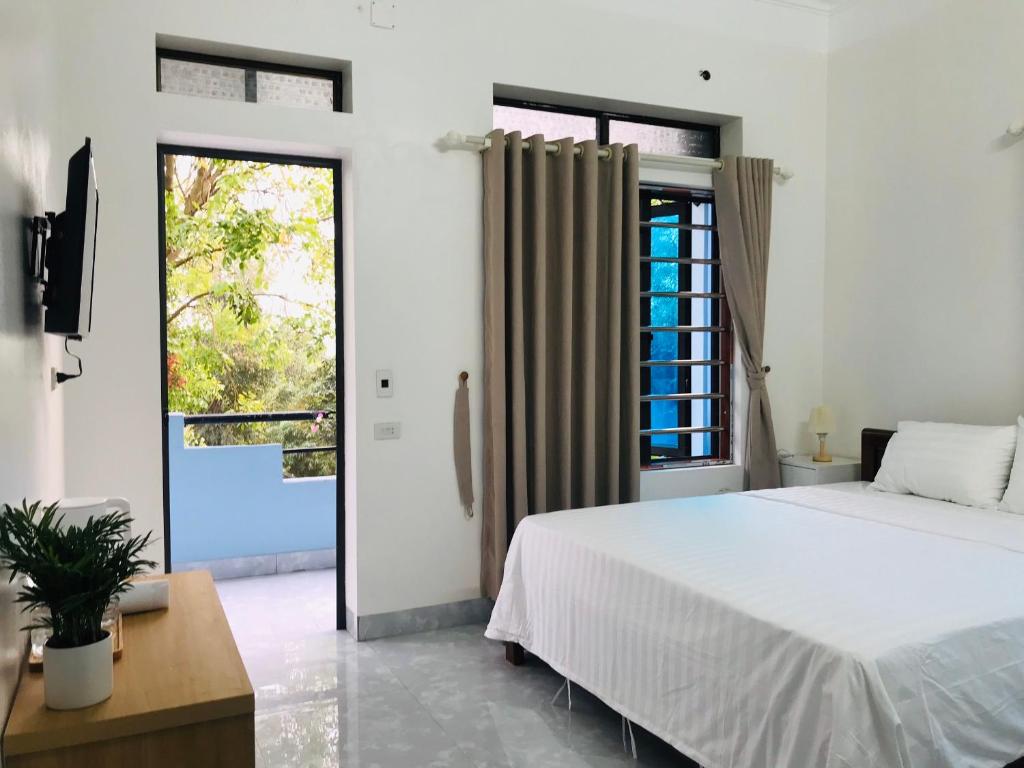 宁平Tam Coc Sunset Homestay的卧室设有白色的床和大窗户
