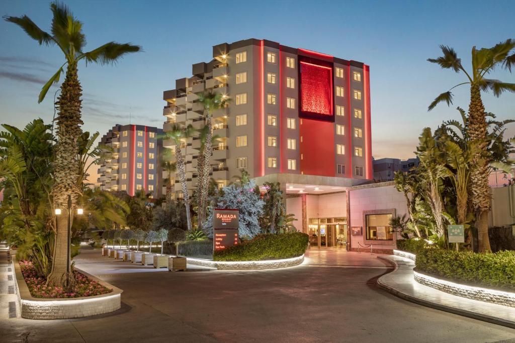 拉瑞Ramada Resort By Wyndham Lara的一座楼前有棕榈树的酒店
