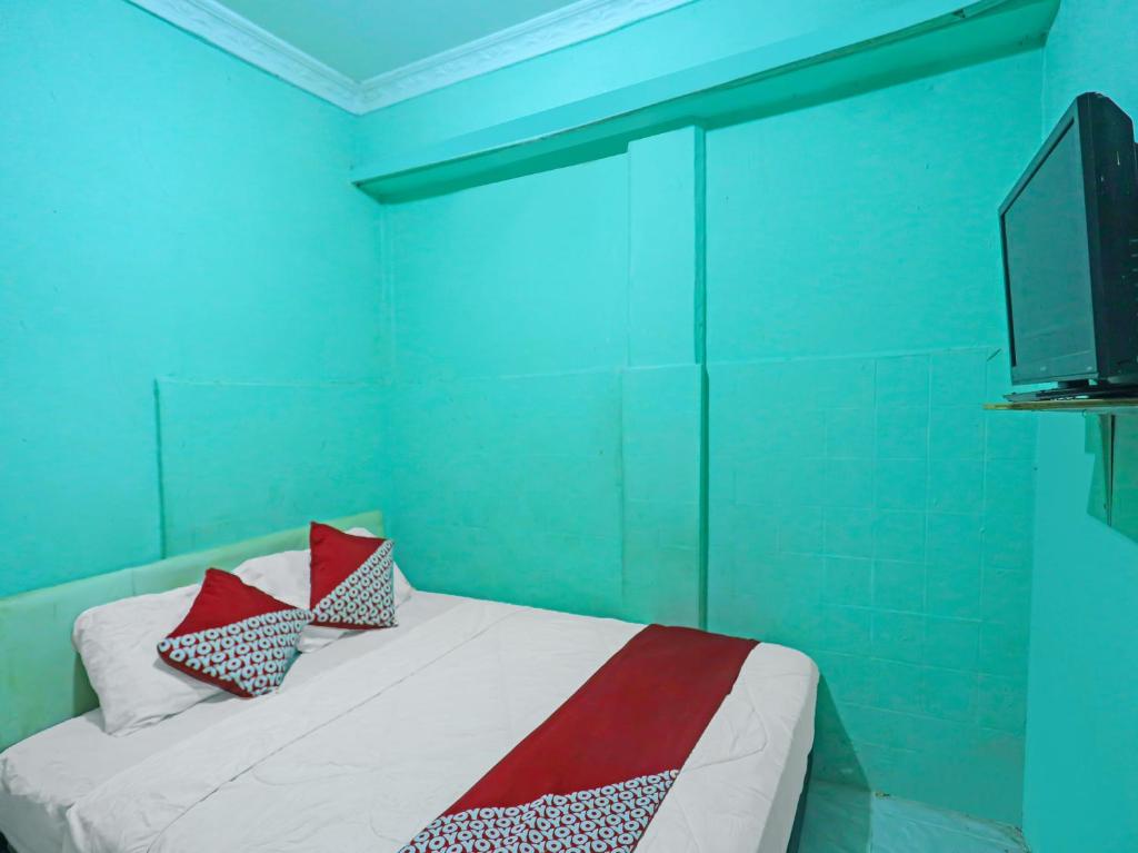 秾莎OYO 92496 Faraas Homestay Syariah的蓝色客房,配有带枕头的床