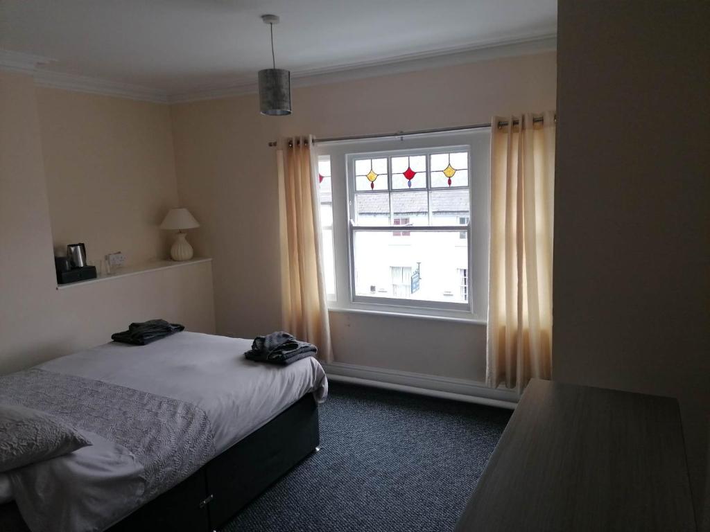 阿什比德拉祖什The Queens Head的一间卧室设有一张床和一个窗口