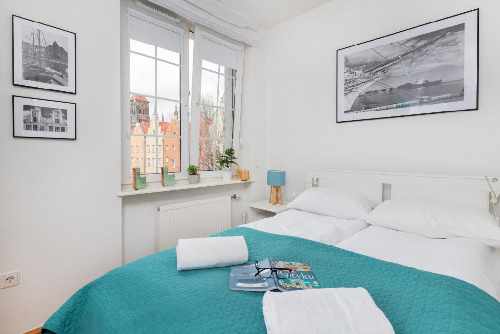 格但斯克Apartment Old Town Gdańsk by Renters的白色卧室配有一张带蓝色毯子的床