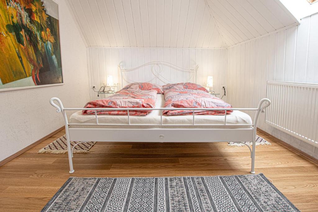 雷德尼斯列支敦士登之屋酒店的客房内的白色床和红色枕头