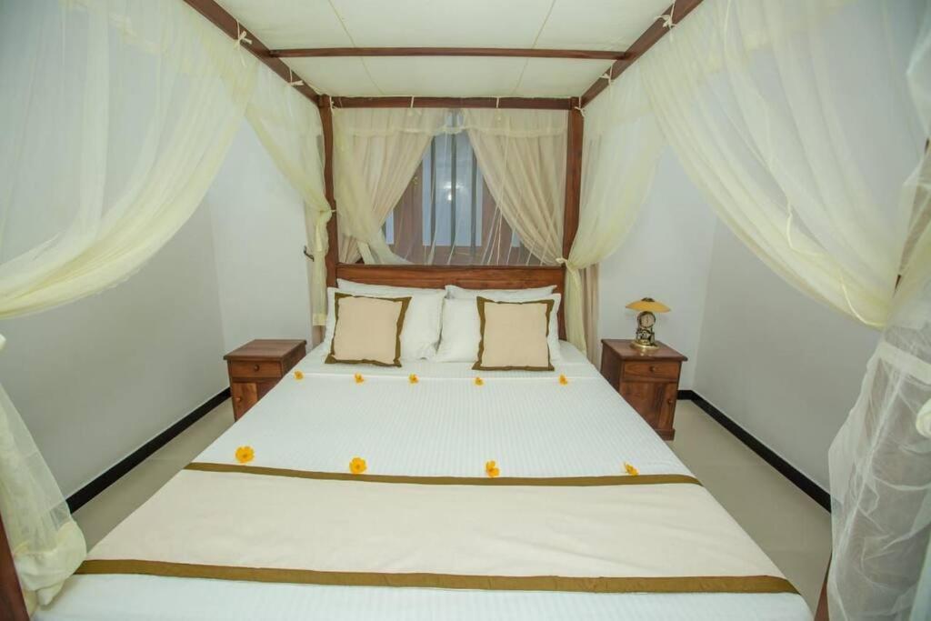 高尔Greenway Apartment的卧室配有一张带白色窗帘的大床