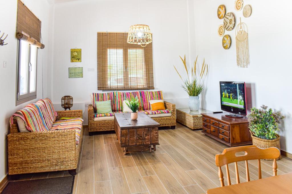 库克里亚Galatia's House的客厅配有柳条家具和电视