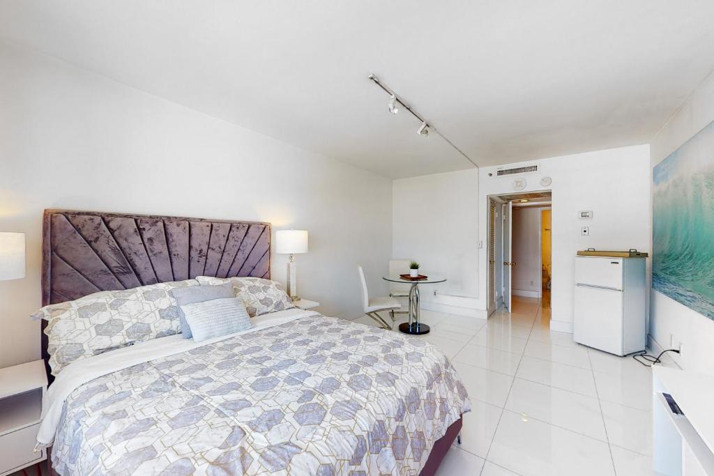 迈阿密海滩Decoplage Paradise - Unit A的一间白色卧室,配有一张大床和一个厨房