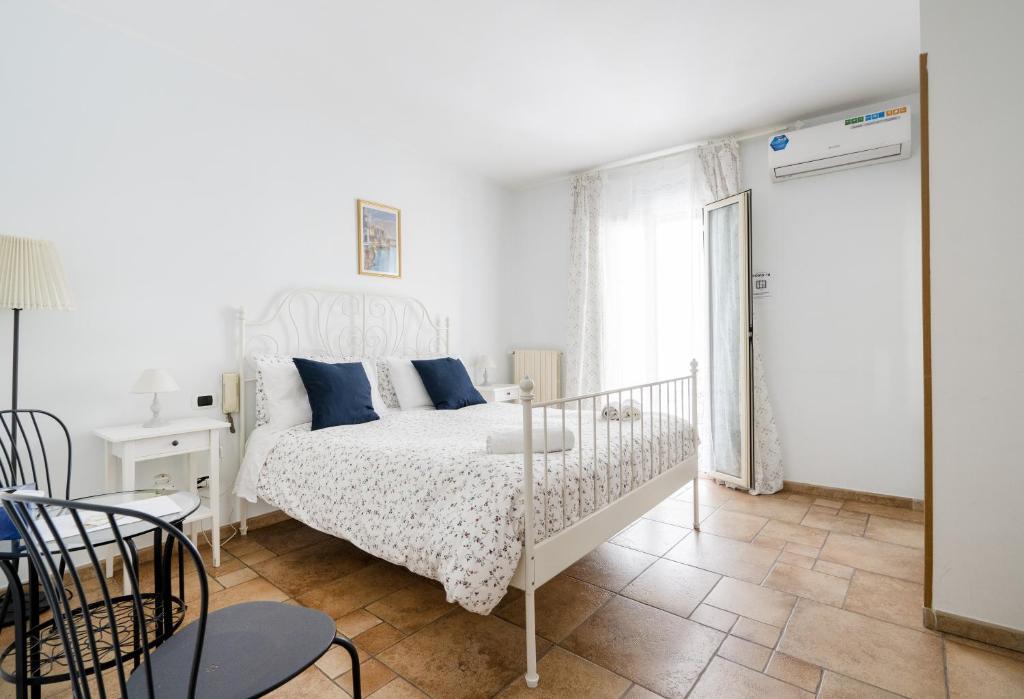 巴里Bella Bari的白色卧室配有白色床和蓝色枕头