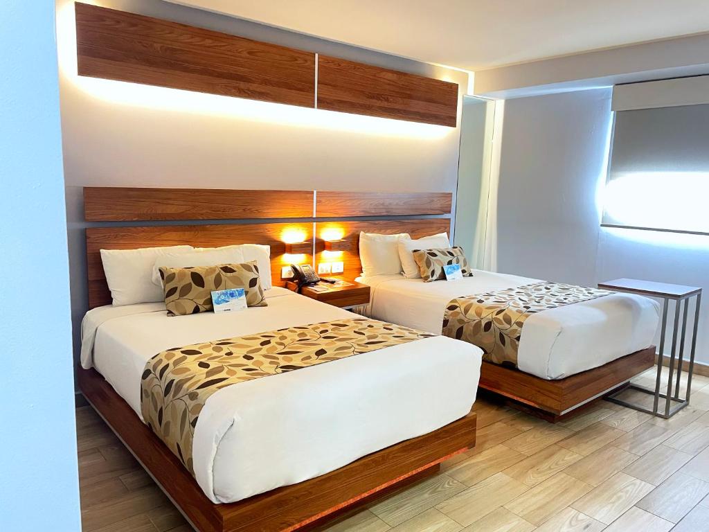 提华纳Sleep Inn Tijuana的酒店客房设有两张床和窗户。