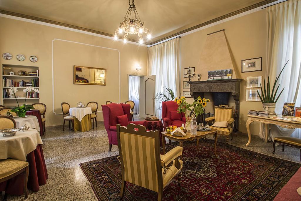 卢卡圣洛伦索酒店的客厅配有桌椅和壁炉