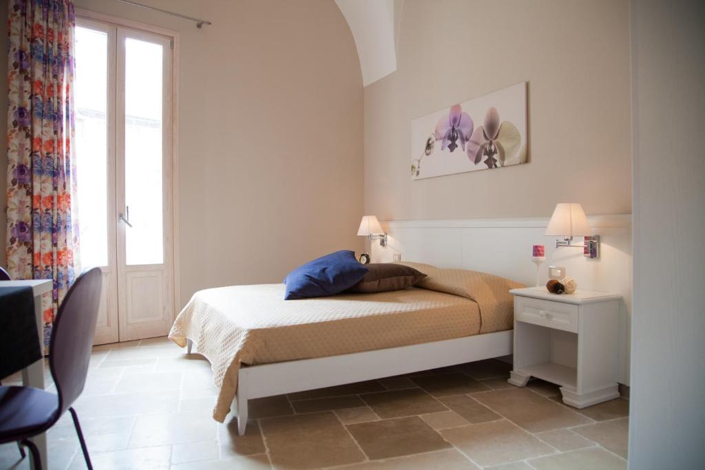 格拉维纳普利亚Le Stanze di Finya的白色的卧室设有床和窗户