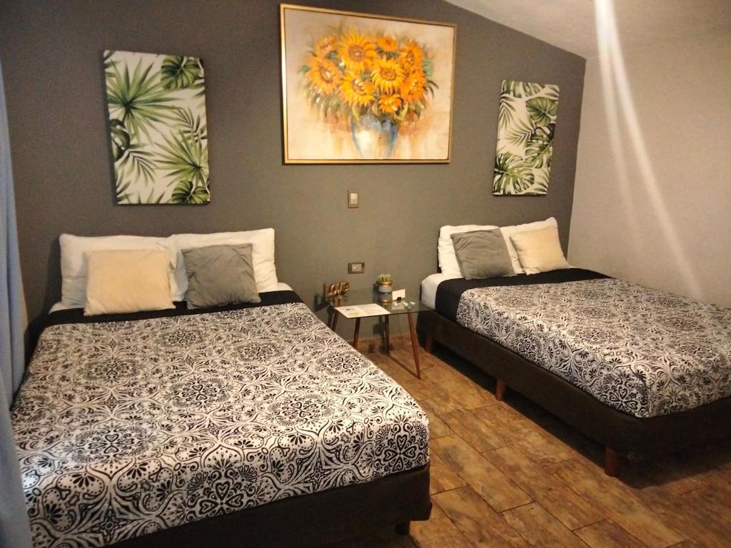 杜兰戈Abitare Durango By Grupo Salazar的一间卧室设有两张床,墙上挂着一幅画
