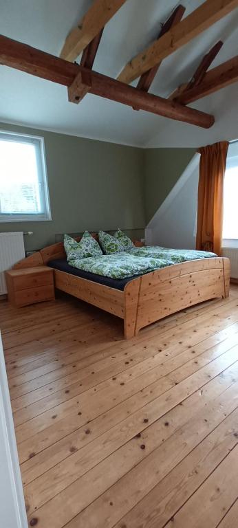 滨湖席弗灵Ferienhaus Familienzeit的一间卧室配有一张木床,铺有木地板