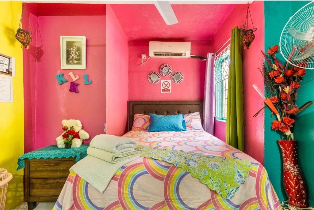蒙特哥贝Colorful Private Room Oasis的色彩缤纷的卧室设有一张床和粉红色的墙壁