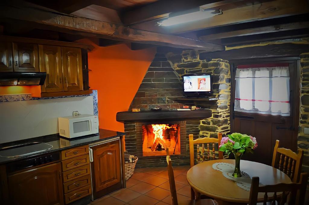 圣埃乌拉利亚德奥斯科斯Casa Freixe Apartamentos Rurales的厨房设有壁炉和前面的桌子。