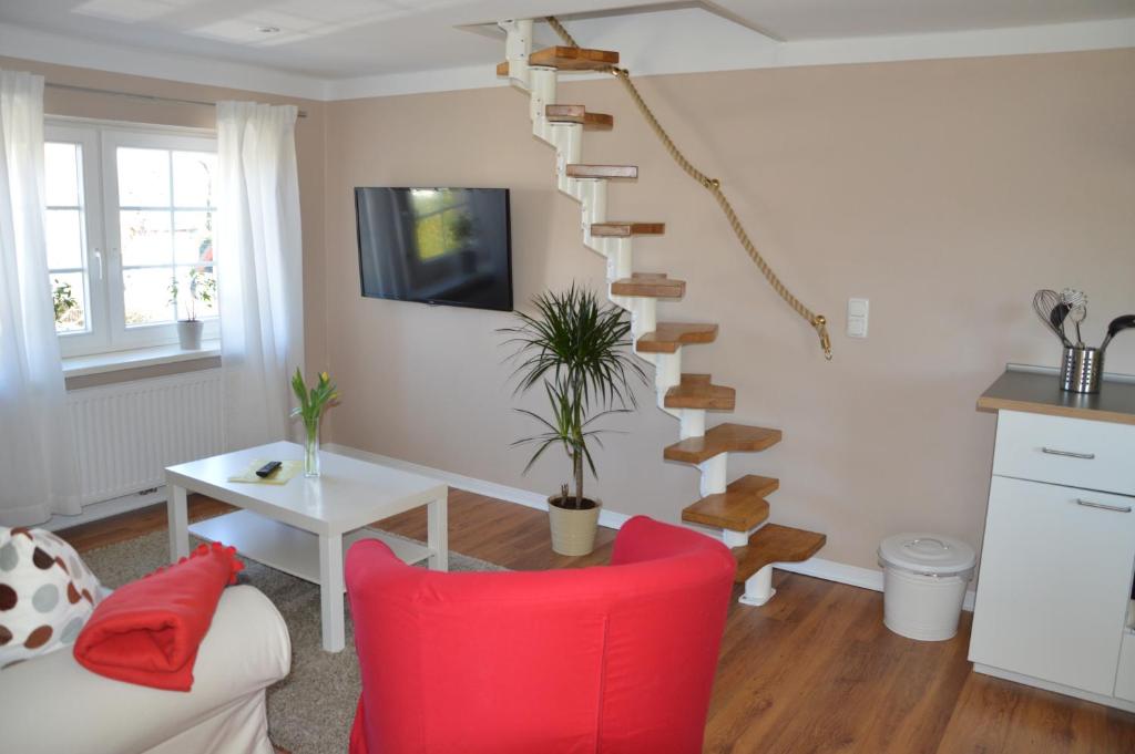 博恩甘希马克特假日公寓的一间带红色椅子和螺旋楼梯的客厅