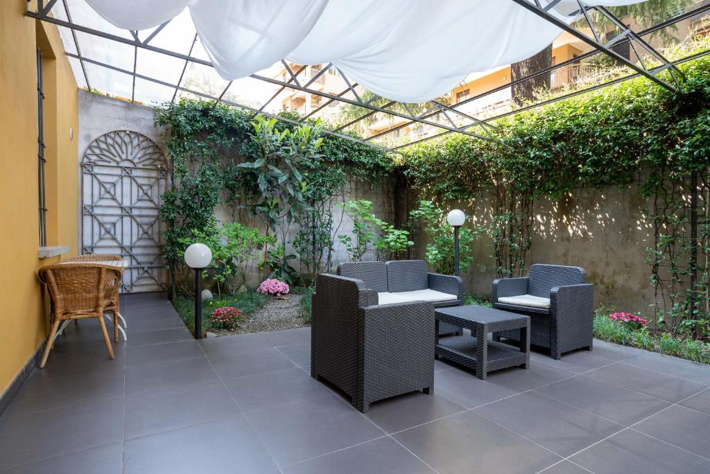 科莫The Secret Garden的庭院设有椅子和植物温室
