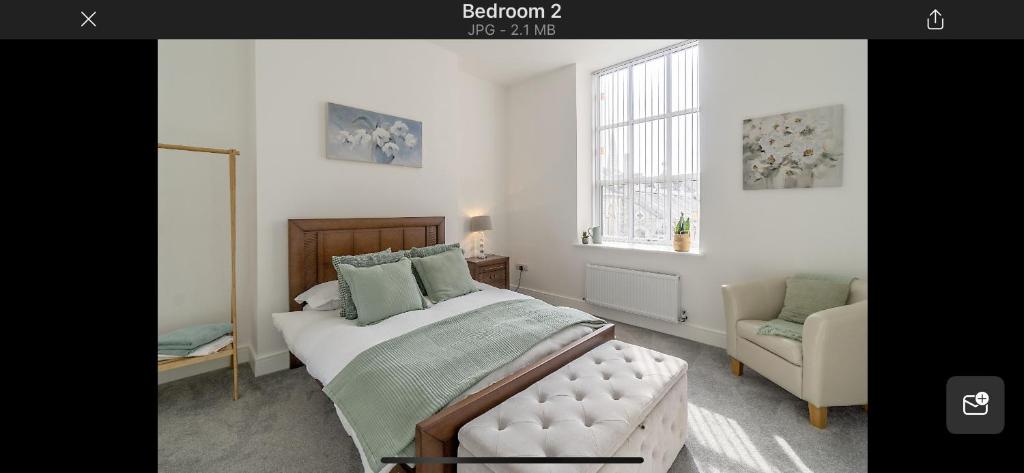 普里茅斯97a 97b Captains House的卧室配有床、椅子和窗户。