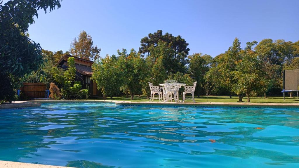 MaipoLoft Cabaña El Recuerdo的庭院内一个带桌椅的游泳池
